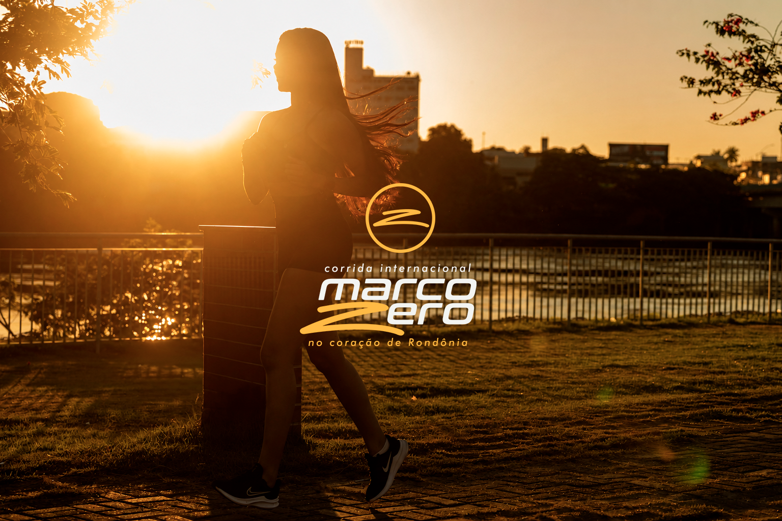 Corredora em Ji-Paraná ao pôr do sol com a marca da Corrida Internacional Marco Zero